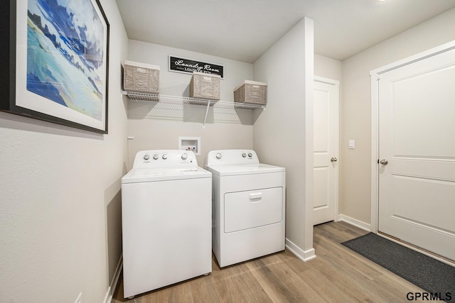 washroom with light wood finished floors, laundry area, separate washer and dryer, and baseboards