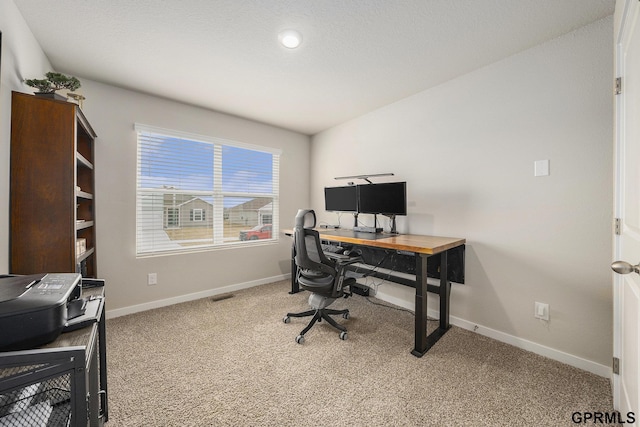 carpeted office space featuring visible vents and baseboards