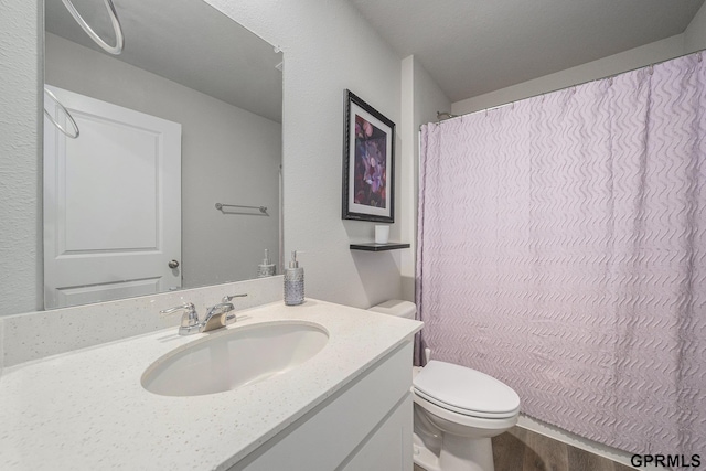 full bathroom with toilet, curtained shower, and vanity