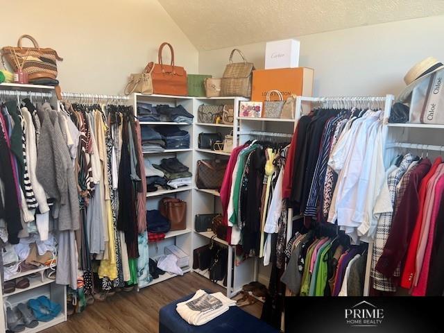 spacious closet with vaulted ceiling and wood finished floors