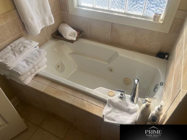 bathroom with a whirlpool tub and tile patterned flooring