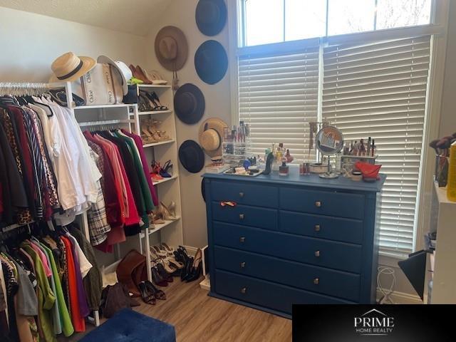 walk in closet with lofted ceiling and light wood-style flooring