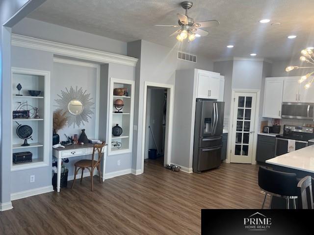 kitchen with light countertops, appliances with stainless steel finishes, visible vents, and white cabinets