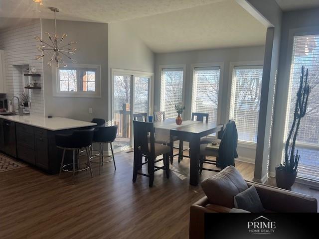 dining room featuring lofted ceiling, dark wood finished floors, and a notable chandelier