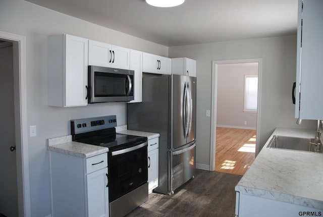 kitchen with white cabinetry, stainless steel appliances, and light countertops