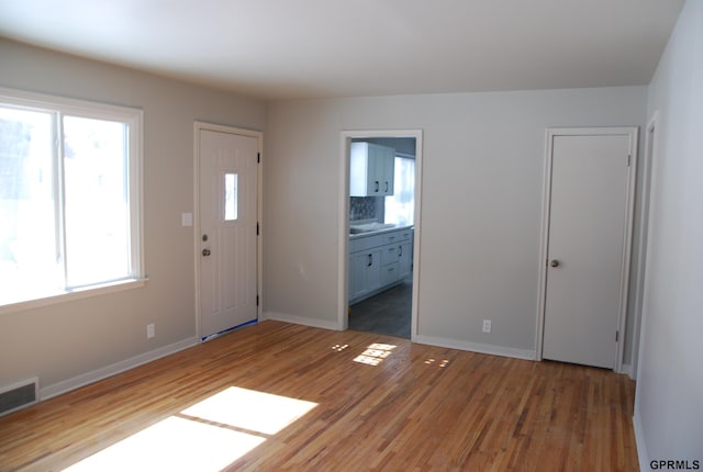 entryway featuring baseboards, visible vents, and wood finished floors