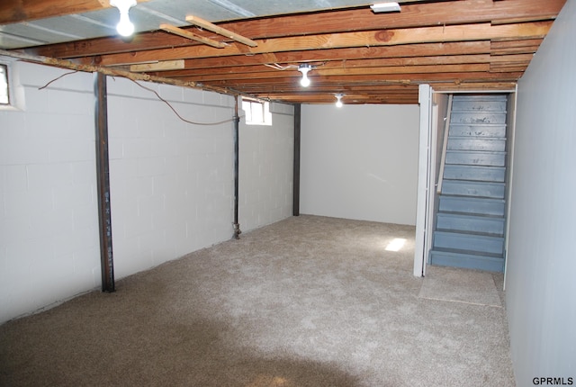 below grade area with light carpet and stairs