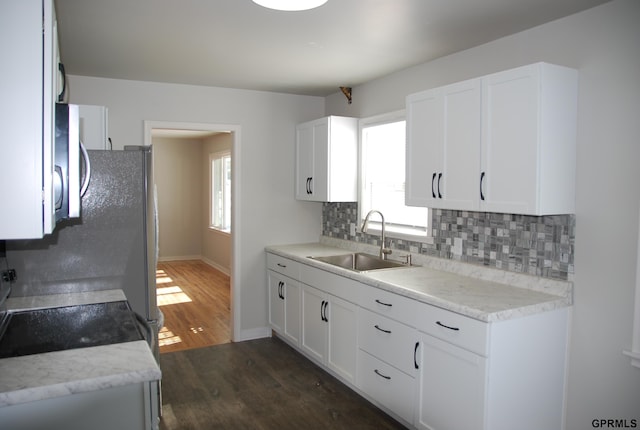 kitchen featuring dark wood-style floors, tasteful backsplash, white cabinets, and a sink