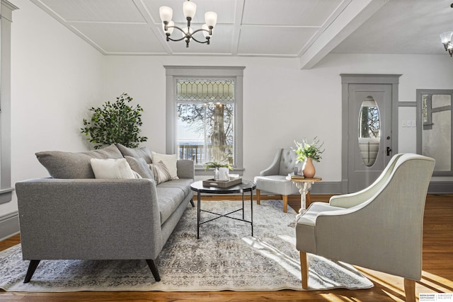 living room with coffered ceiling, wood finished floors, and a notable chandelier