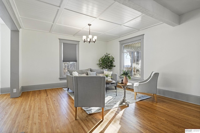 living room with baseboards, a chandelier, a wealth of natural light, and wood finished floors