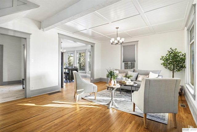 living area with a chandelier, wood finished floors, and visible vents