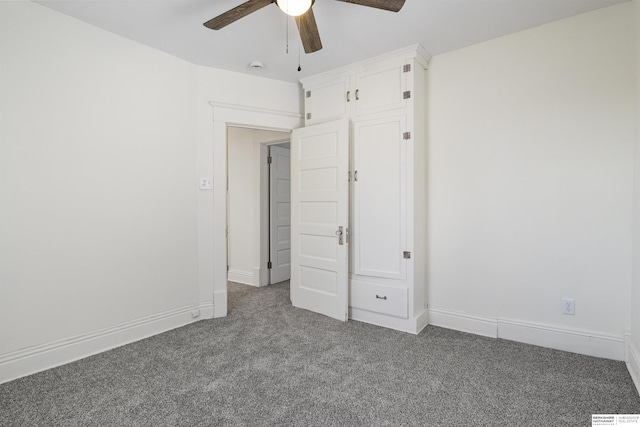 unfurnished bedroom with dark carpet, a ceiling fan, and baseboards