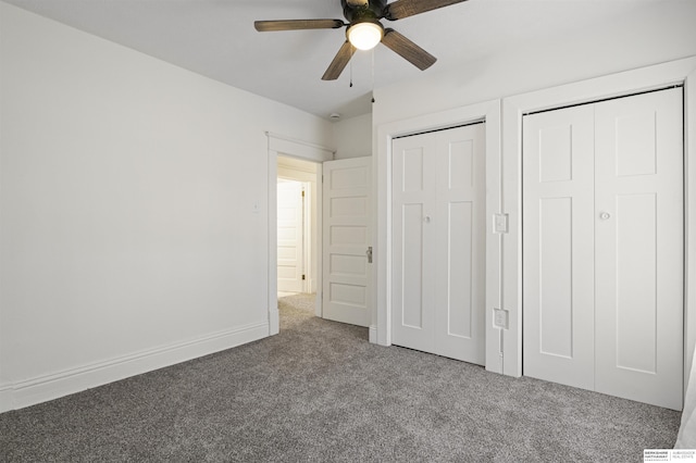 unfurnished bedroom with multiple closets, carpet flooring, ceiling fan, and baseboards