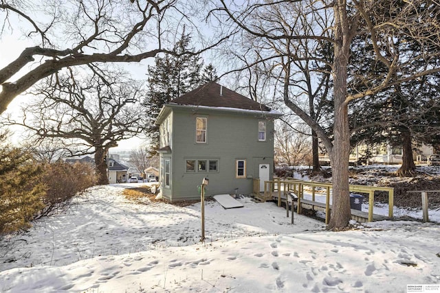 view of snow covered rear of property