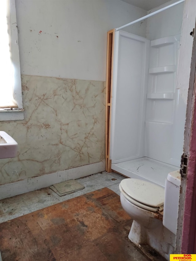 full bath featuring a stall shower and toilet