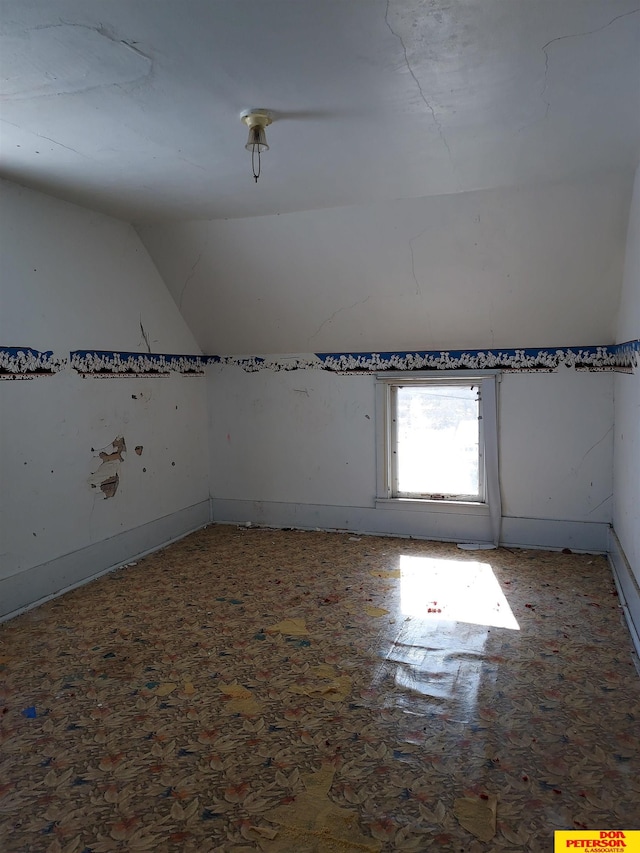 additional living space featuring lofted ceiling