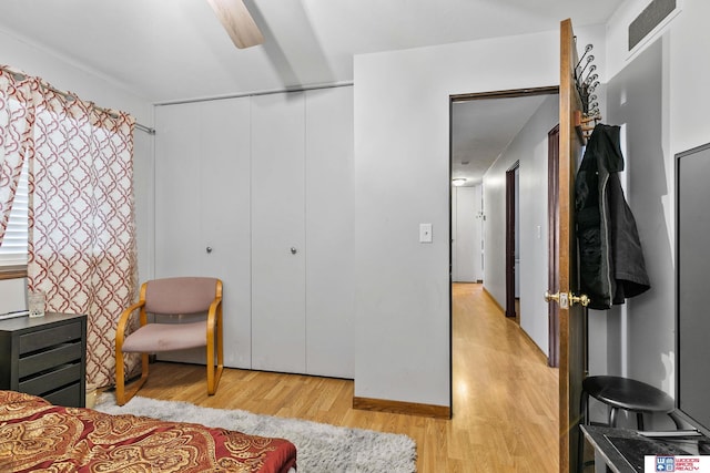 bedroom featuring light wood-style flooring, visible vents, ceiling fan, and a closet