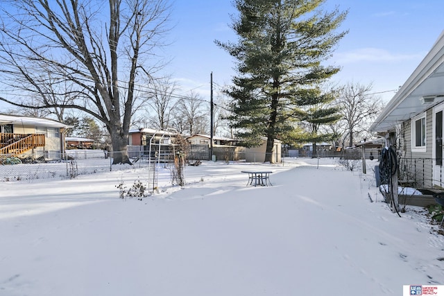 yard layered in snow featuring fence