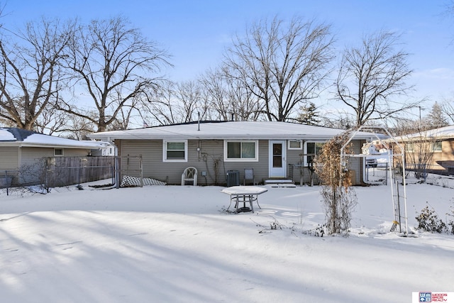 snow covered house with fence