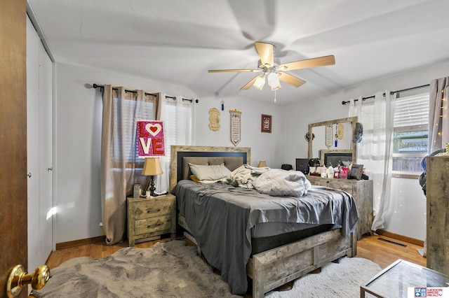 bedroom featuring a ceiling fan, visible vents, light wood-style flooring, and baseboards