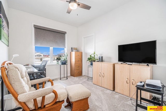 living area featuring ceiling fan, baseboards, and light colored carpet