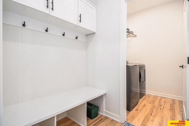 mudroom featuring light wood-style flooring, baseboards, and separate washer and dryer