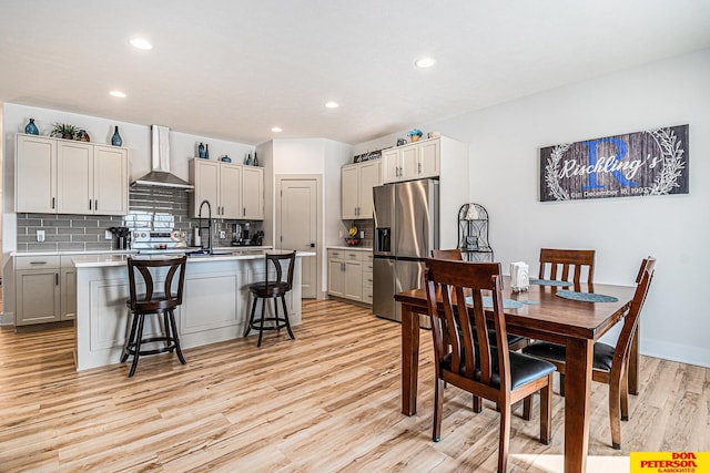 dining area with light wood finished floors and recessed lighting