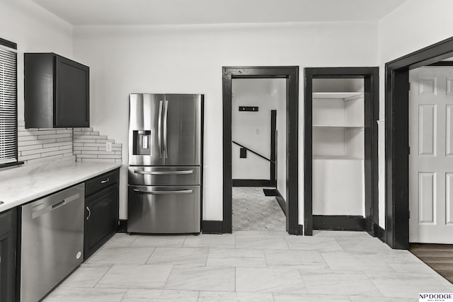 kitchen featuring decorative backsplash, appliances with stainless steel finishes, light countertops, and dark cabinets