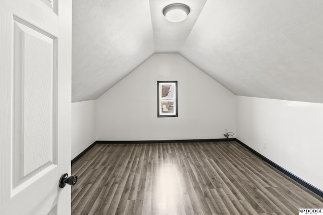 additional living space featuring lofted ceiling, baseboards, and wood finished floors