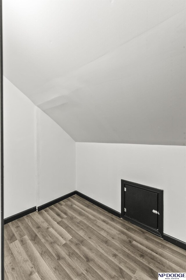 bonus room featuring vaulted ceiling, wood finished floors, and baseboards