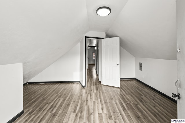 bonus room with lofted ceiling, dark wood-style flooring, and baseboards