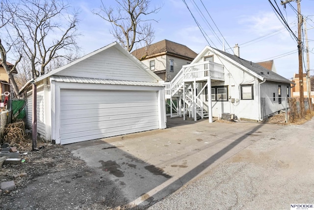 view of front of property featuring a garage, an outbuilding, and stairs