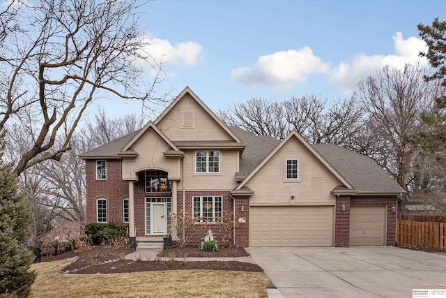 traditional home with a garage, concrete driveway, brick siding, and fence