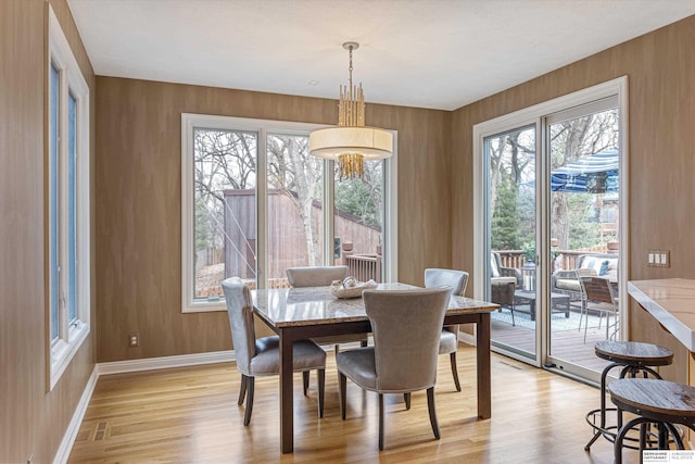 dining area with baseboards, plenty of natural light, and light wood-style floors