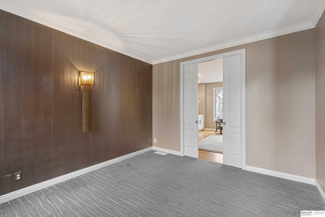 spare room featuring carpet floors, baseboards, and ornamental molding