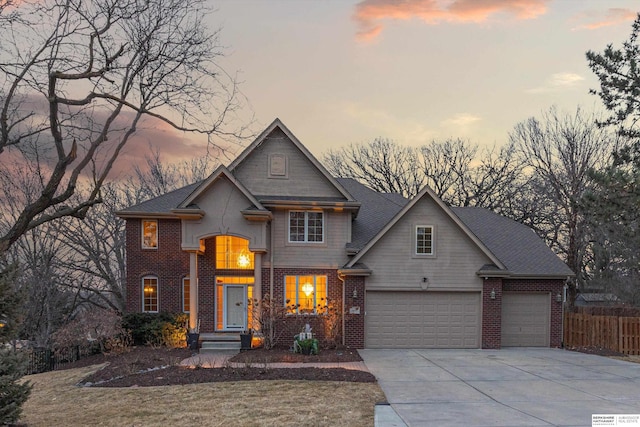 traditional-style home with driveway, a garage, fence, and brick siding