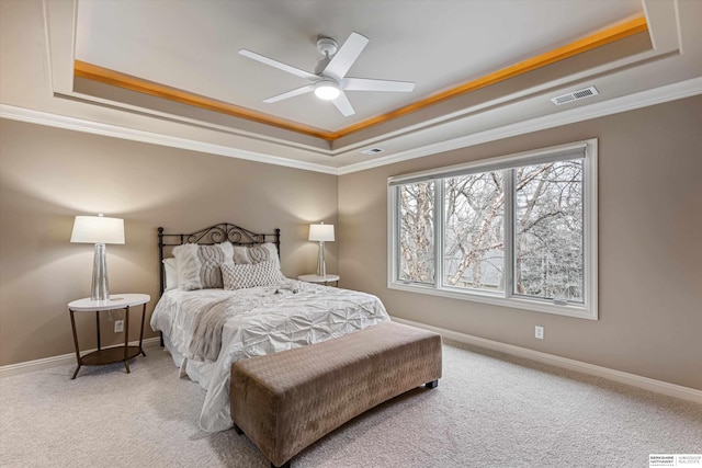 bedroom with carpet, visible vents, and a raised ceiling