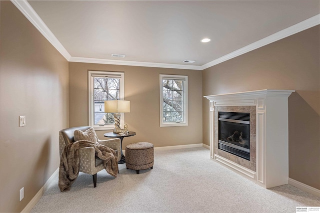 living area featuring light colored carpet, visible vents, baseboards, ornamental molding, and a tiled fireplace