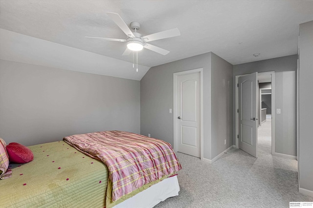 bedroom featuring vaulted ceiling, baseboards, a ceiling fan, and light colored carpet