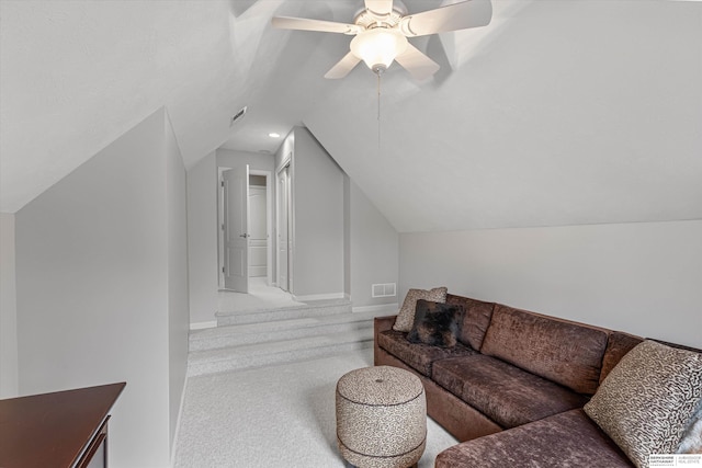 carpeted living area with vaulted ceiling, baseboards, visible vents, and a ceiling fan