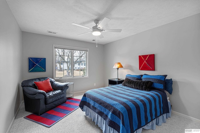 bedroom featuring a textured ceiling, carpet flooring, visible vents, baseboards, and a ceiling fan