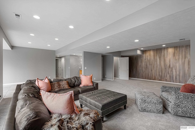 living area featuring light colored carpet, visible vents, wooden walls, and recessed lighting