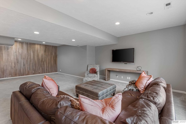 carpeted living room with recessed lighting, visible vents, wooden walls, and baseboards