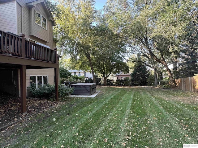 view of yard featuring fence and a hot tub