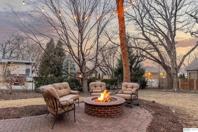 patio terrace at dusk with an outdoor fire pit and fence