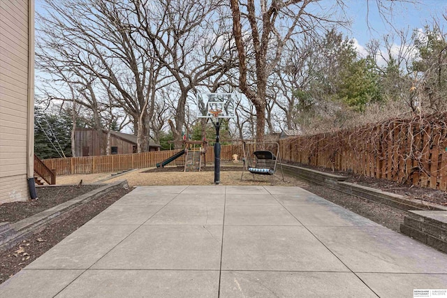 view of sport court with a fenced backyard and a playground