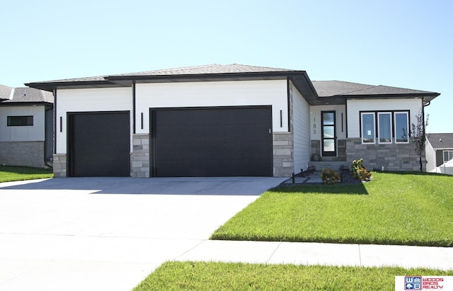 prairie-style house featuring a garage, stone siding, and concrete driveway