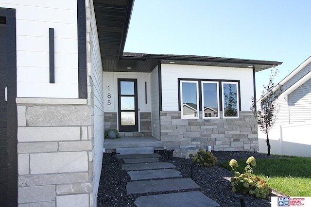 doorway to property with stone siding