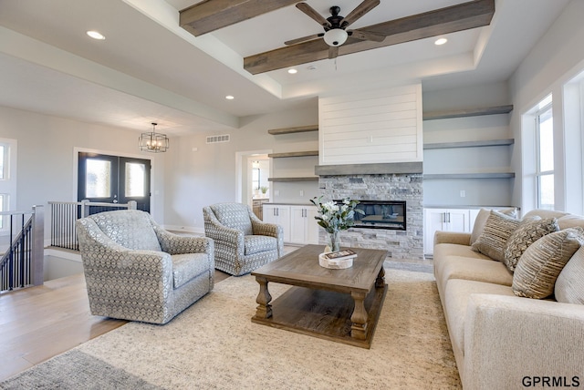 living area featuring a fireplace, recessed lighting, visible vents, light wood-style floors, and beamed ceiling