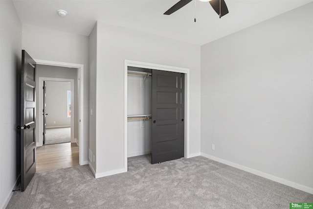 unfurnished bedroom with carpet, a closet, and baseboards